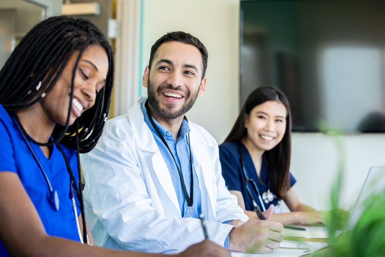 A care team of clinicians conferring in a clinic hallway
